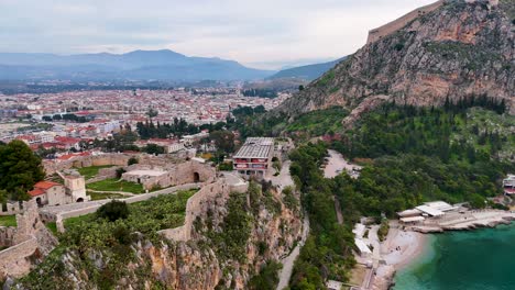 Drone-Reveal-of-Nafplio-City-with-the-Fortress-of-Akronafplia-in-the-Foreground,-Peloponnese-Region,-Greece