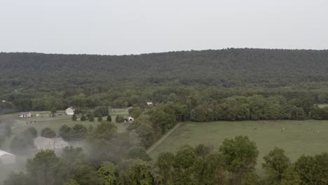 dji mavic 2 pro shot of a mountain overseeing a wide valley area with mist coming from the right side in 4k 24p d-log