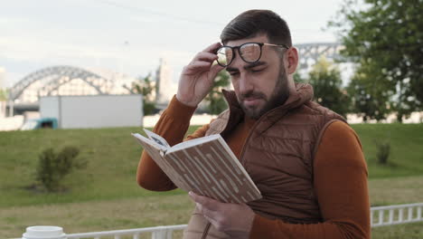 man reading funny book outdoors