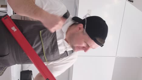 funny and fun kitchen furniture assembler simulates playing the guitar with a construction level funny and fun kitchen furniture assembler simulates playing the guitar with a construction level happy young worker of european appearance at work