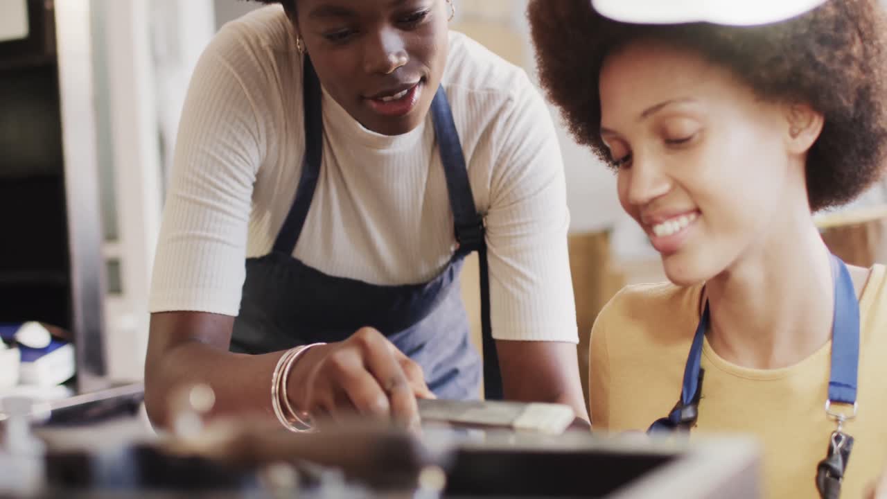 Busy diverse female workers shaping ring with handcraft tools in studio in slow motion