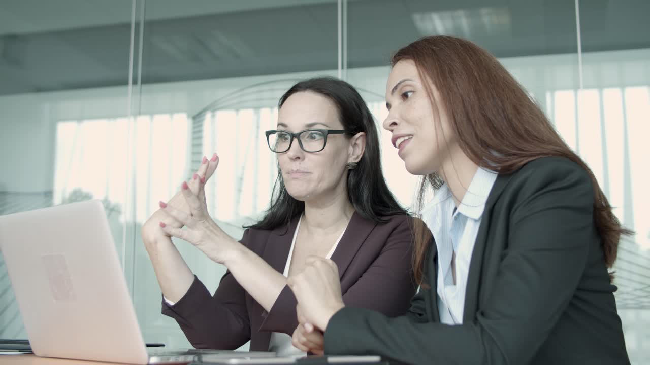 mujeres de negocios jóvenes hablando, chateando por video a través de la computadora portátil