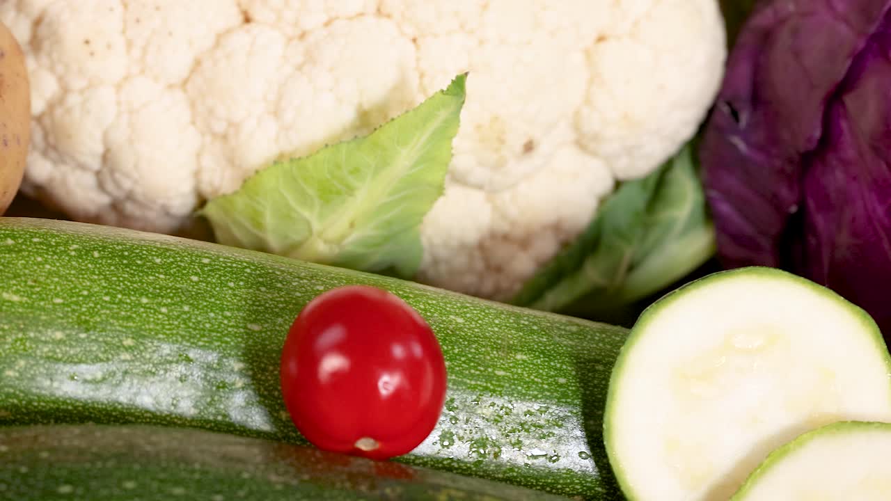 카라플라워, zucchini, 체리 토마토를 포함한 신선한 채소의 활기찬 디스플레이, 밝은 조명으로 유기농 제품을 전시