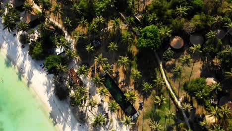 An-aerial-orbit-drone-shot-of-Shark-Bay-beach,-showing-its-white-sandy-coastline,-luxurious-villas,-tropical-cabanas,-and-some-tourists-lazing-by-the-beachfront,-in-Kho-Tao-island,-Thailand