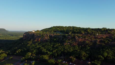 Toma-Aérea-De-Un-Dron-En-Movimiento-Hacia-Atrás-Del-Cerro-Yaguaron,-Que-Es-Un-Montículo-En-Paraguay-En-América-Del-Sur-Al-Atardecer