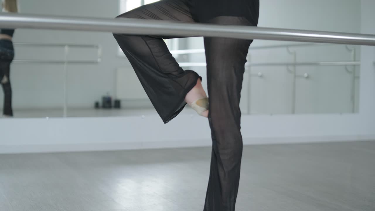 chica en forma con ropa negra actuando contemporáneamente. bailarina muestra movimientos fluidos, cuerpo y manos ondas en la habitación blanca. coreografía de danza de ballet moderno. joven se mueve suavemente
