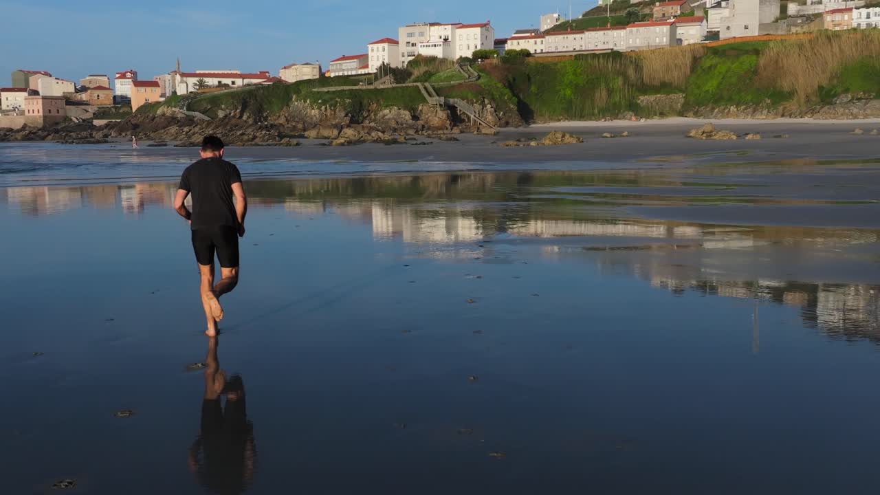 Man Running Barefoot On The Shores Of Praia de Caión In A Coruna, Spain. Slow Motion Shot