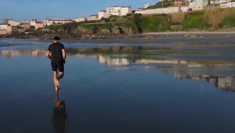 man running barefoot on the shores of praia de caión in a coruna, spain. slow motion shot