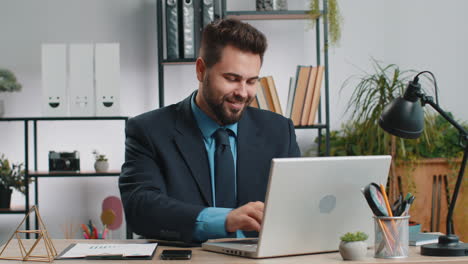 Caucasian business man freelancer at office start working on laptop computer sends online messages