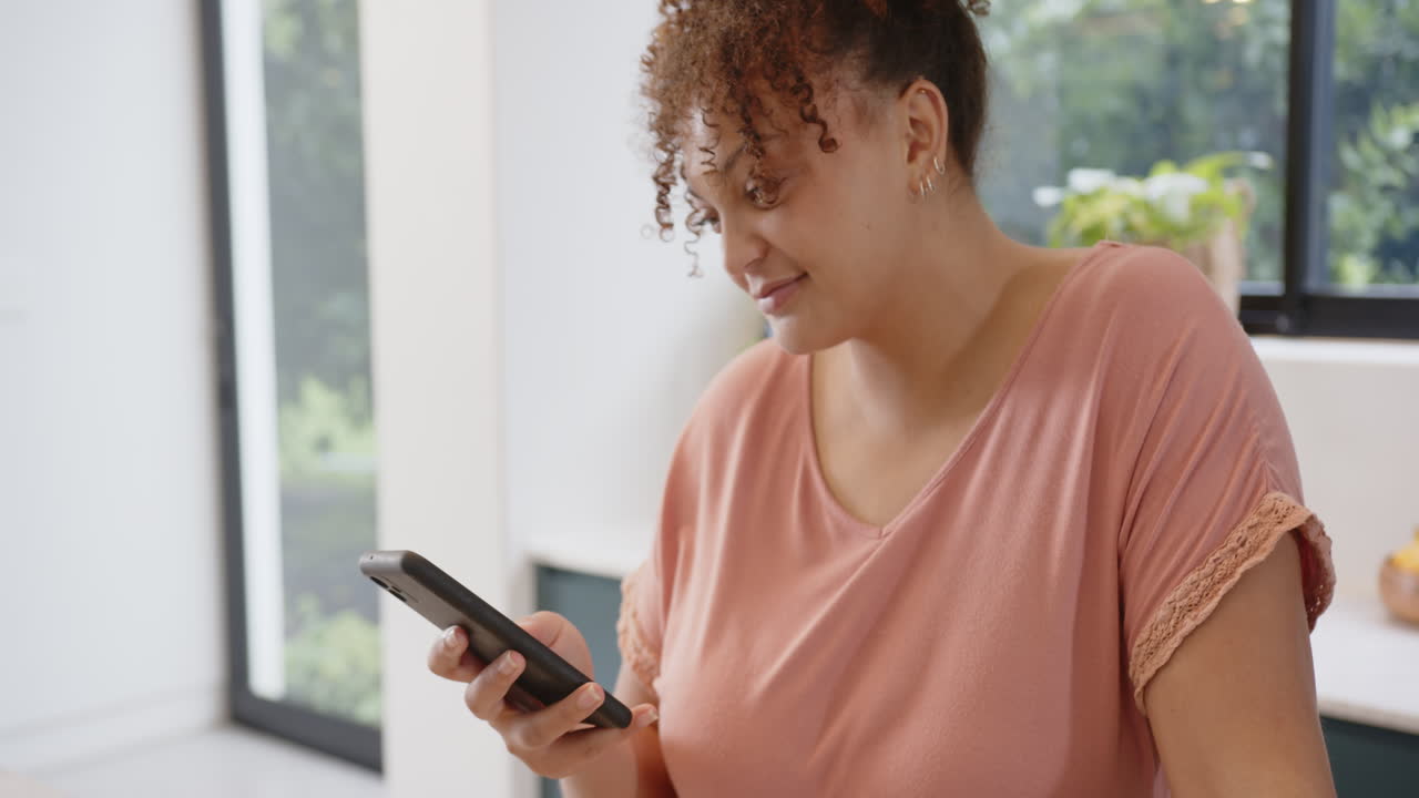 Using smartphone, plus size woman smiling and engaging with fitness app