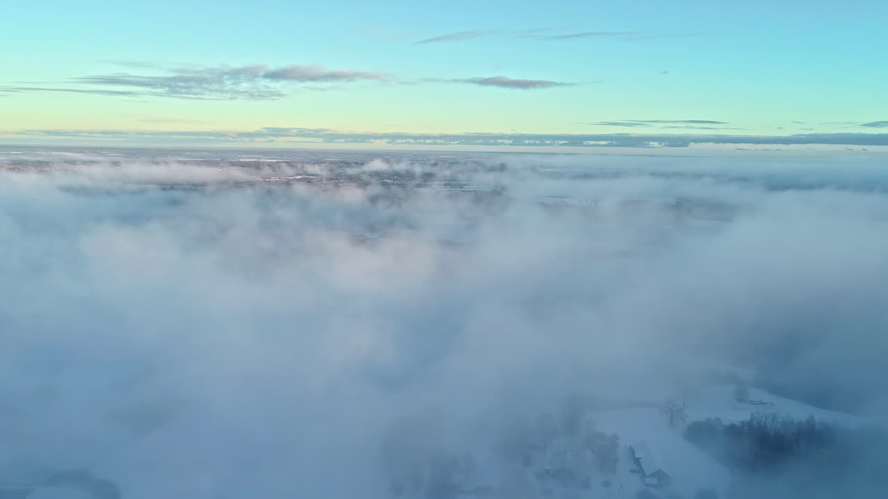 increíble vista de pájaro del paisaje nevado y el bosque de coníferas a través de las nubes