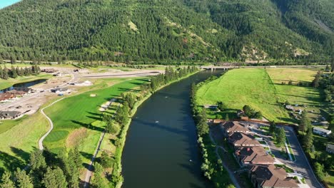 Vista-Aérea-De-Un-Río-Idílico-Entre-Campos-Verdes-En-Saint-Anthony,-Idaho,-Estados-Unidos---Disparo-De-Drones