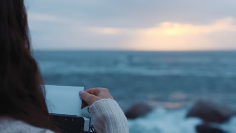 young woman photographer taking photos on beach using camera enjoying photographing cloudy day