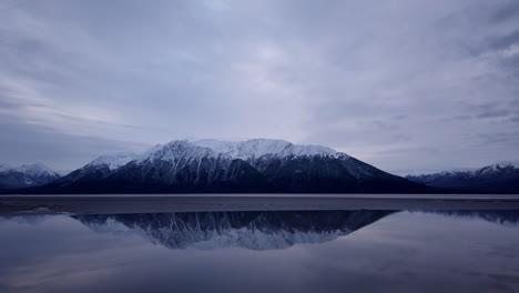 timelapse of dark clouds as they pass over snowy mountains and turnagain arm in alaska