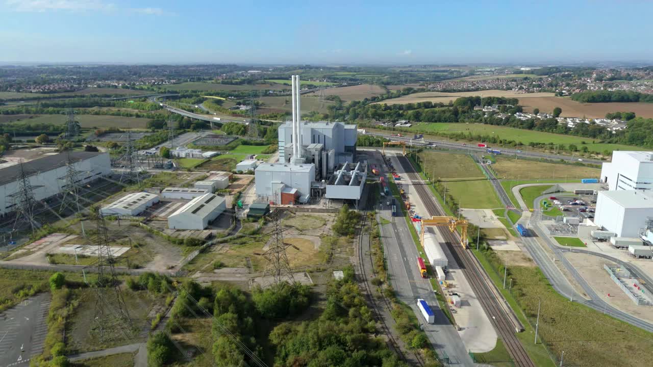 Aerial drone shot of Ferrybridge biomass energy generation plant with chimneys, smoke plumes and industrial infrastructure on sunny summer day Yorkshire UK