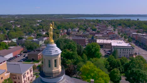 Drone-pull-away-view-of-the-city-and-the-gold-statue-of-the-Beautiful-Courthouse-in-Canandaigua,-New-York-near-Canandaigua-Lake