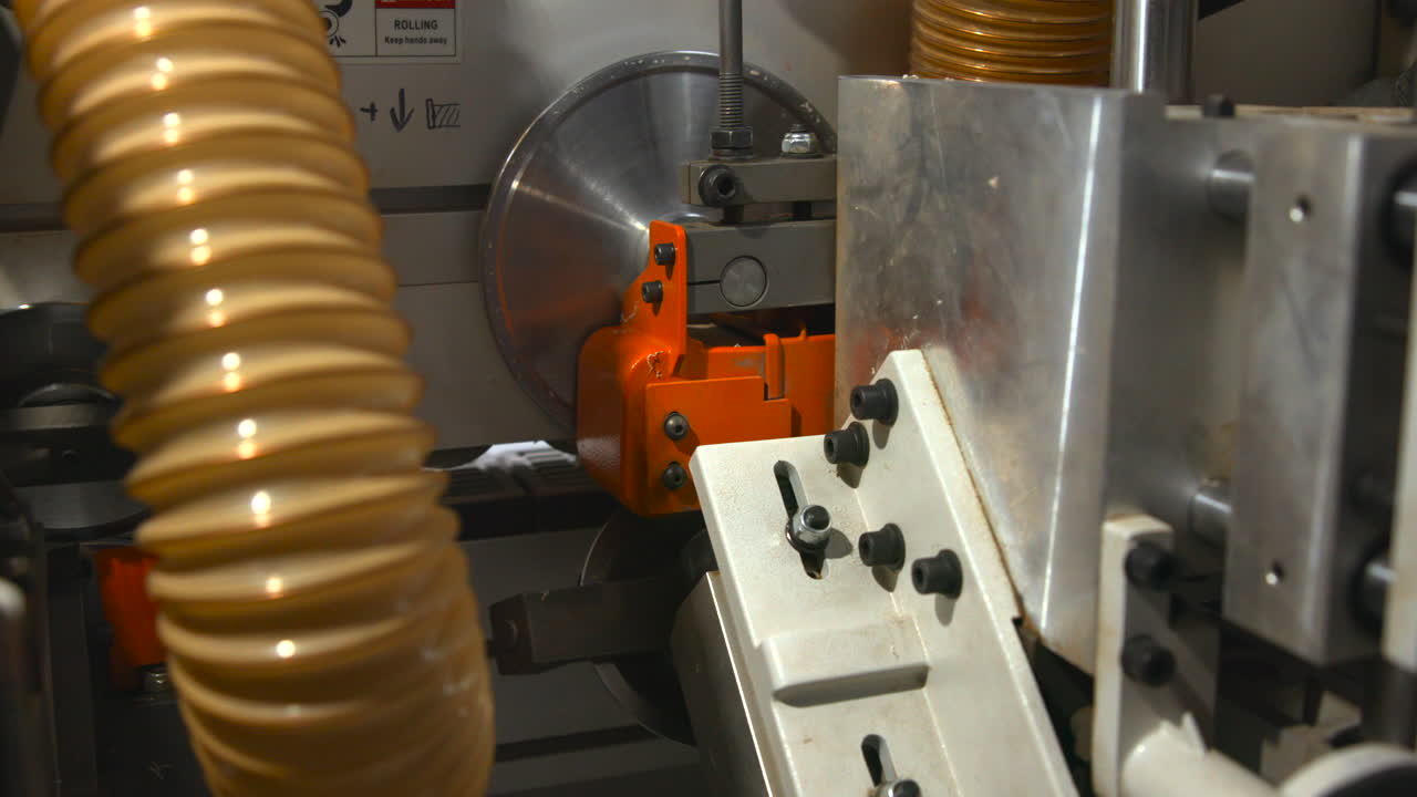 Close-up de máquina industrial de marcenaria com sistema de extração de pó e sinal de segurança