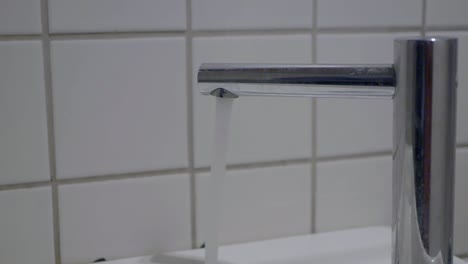 agua corriente del grifo del sensor en el baño