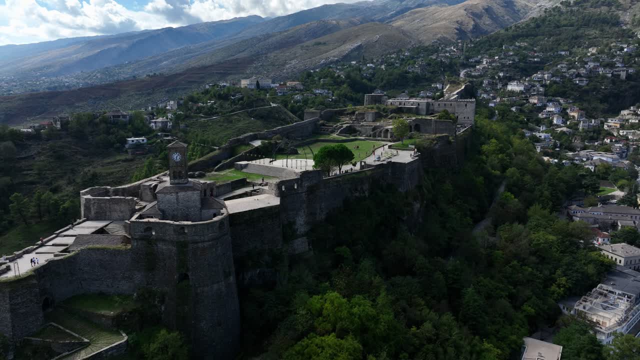 Aerial of Gjirokaster Castle and surrounding Albanian hillside town in bright daylight