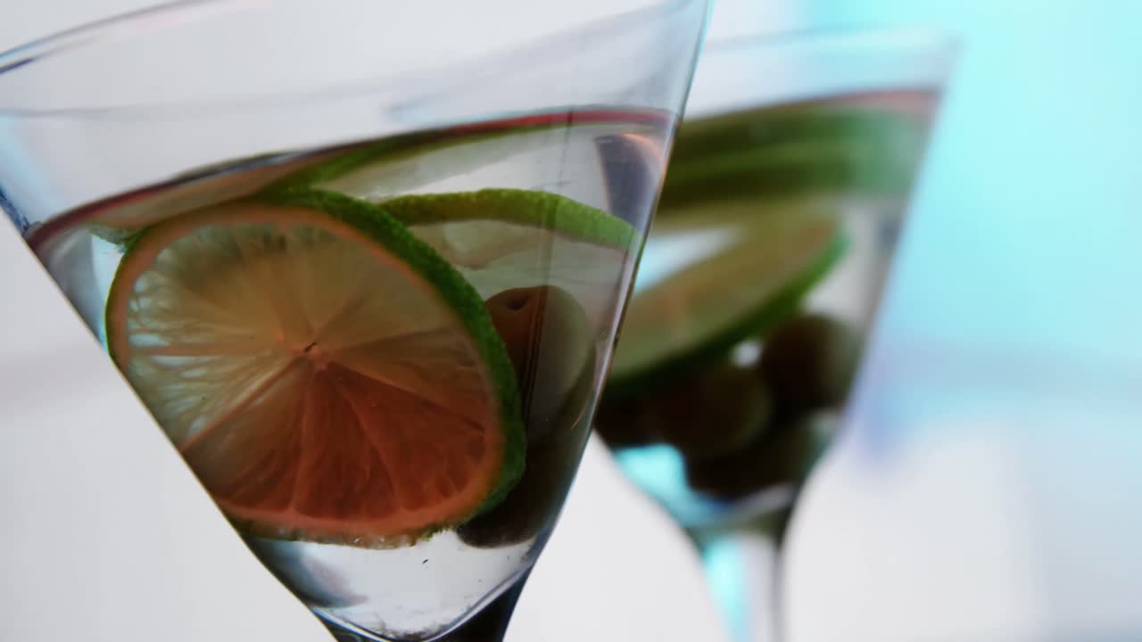 Fette di limone e olive nel bicchiere di cocktail