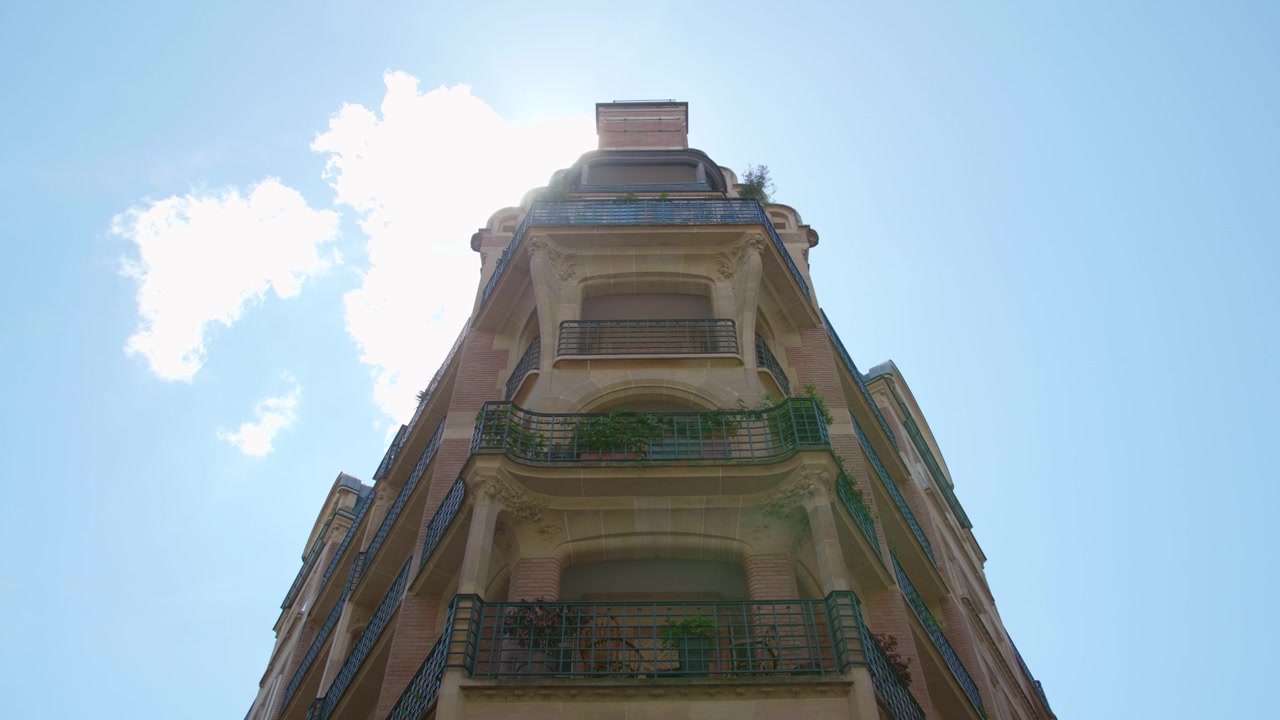 Design esterno di un edificio commerciale al 6 Rue Villaret de Joyeuse a Parigi, Francia, contro un cielo azzurro brillante. Angolazione bassa.