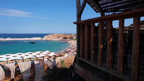 Beach-Bar-and-Sandy-Shore-of-Greek-Coastline,-Sithonia-on-Hot-Sunny-Summer-Day