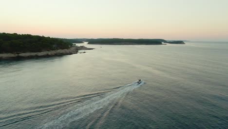 Ein-Boot,-Das-Diagonal-über-Den-Rahmen-In-Das-Morgendliche-Sonnenaufgangslicht-Segelt