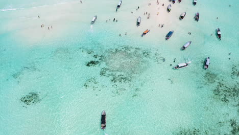 motorboats cruising around shallow tropical sandbank with people