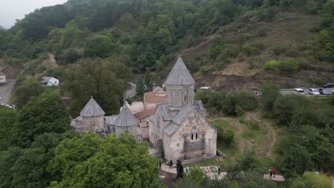 aerial orbits medieval haghartsin monastery, tourists explore grounds