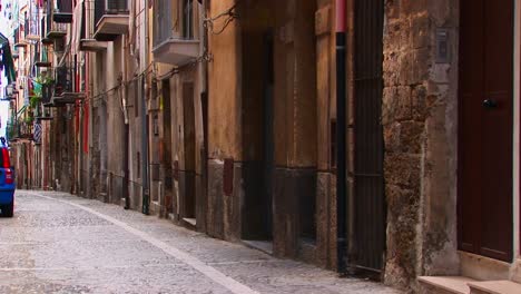 A-rock-street-near-closely-placed-houses-and-balconies-in-Cefalu-Italy----