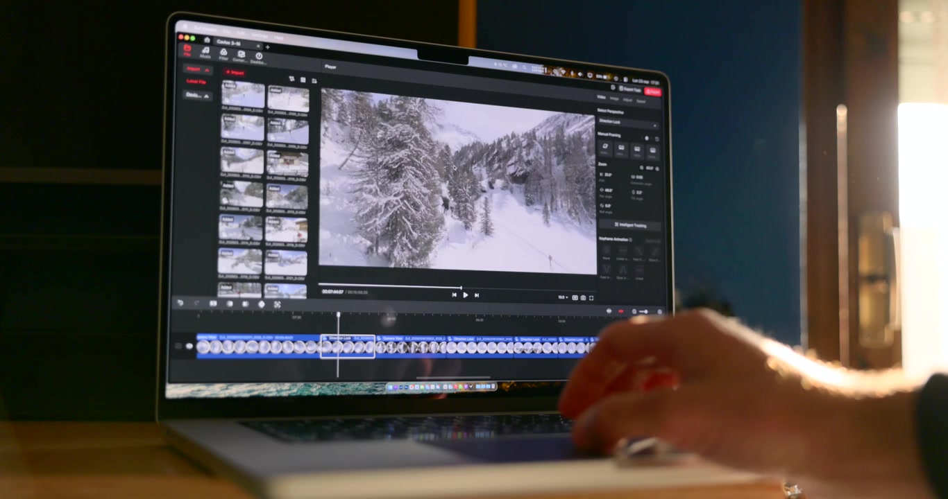 Close-up view of hand using trackpad to edit video timeline on laptop computer display screen in studio