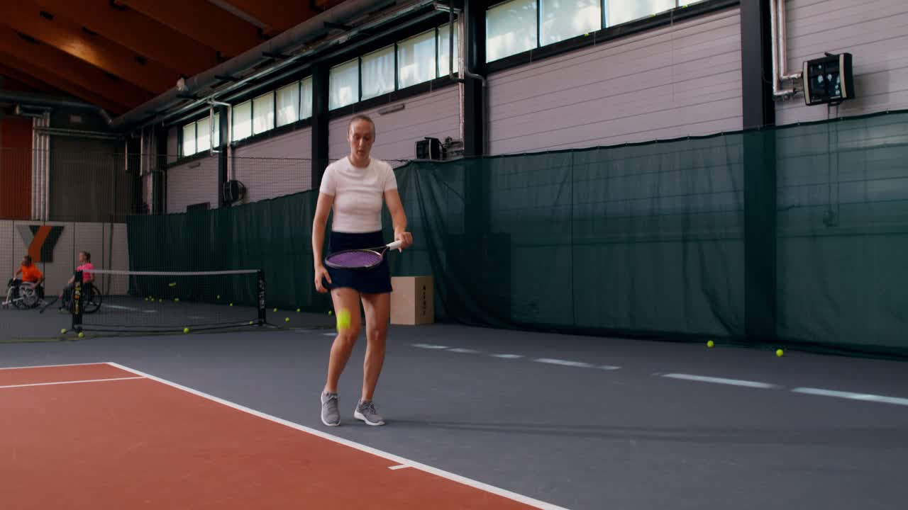 Una mujer jugando al tenis en interiores