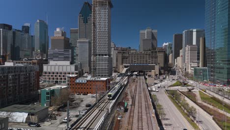 aerial of rem automated light rail system subway train entering montreal city with skyline building in quebec capital , canada