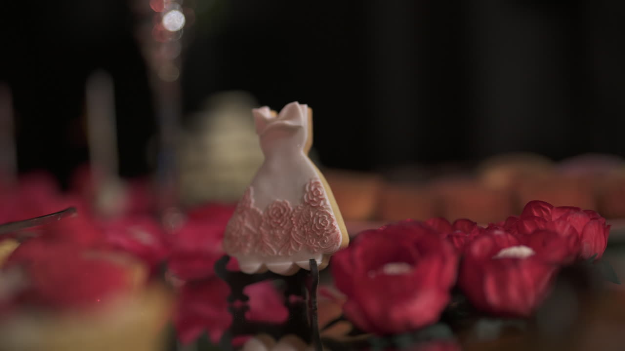 부드러운 초점에 활기찬 빨간 꽃으로 둘러싸인 작은 장식적인 설탕 드레스