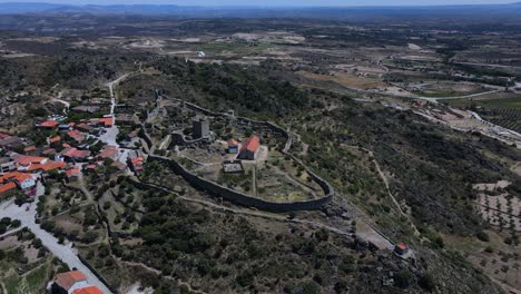 Aerial-view-of-old-castle-surrounded-by-an-ancient-village-in-Portugal