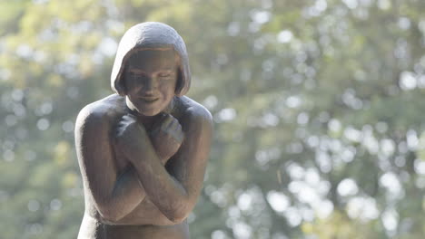 left of frame, woman with crossed arms sculpture in vigeland park, oslo