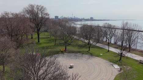 aerial: lake shore boulevard, lake ontario and downtown toronto skyline during the day in ontario, canada, crane up drone shot