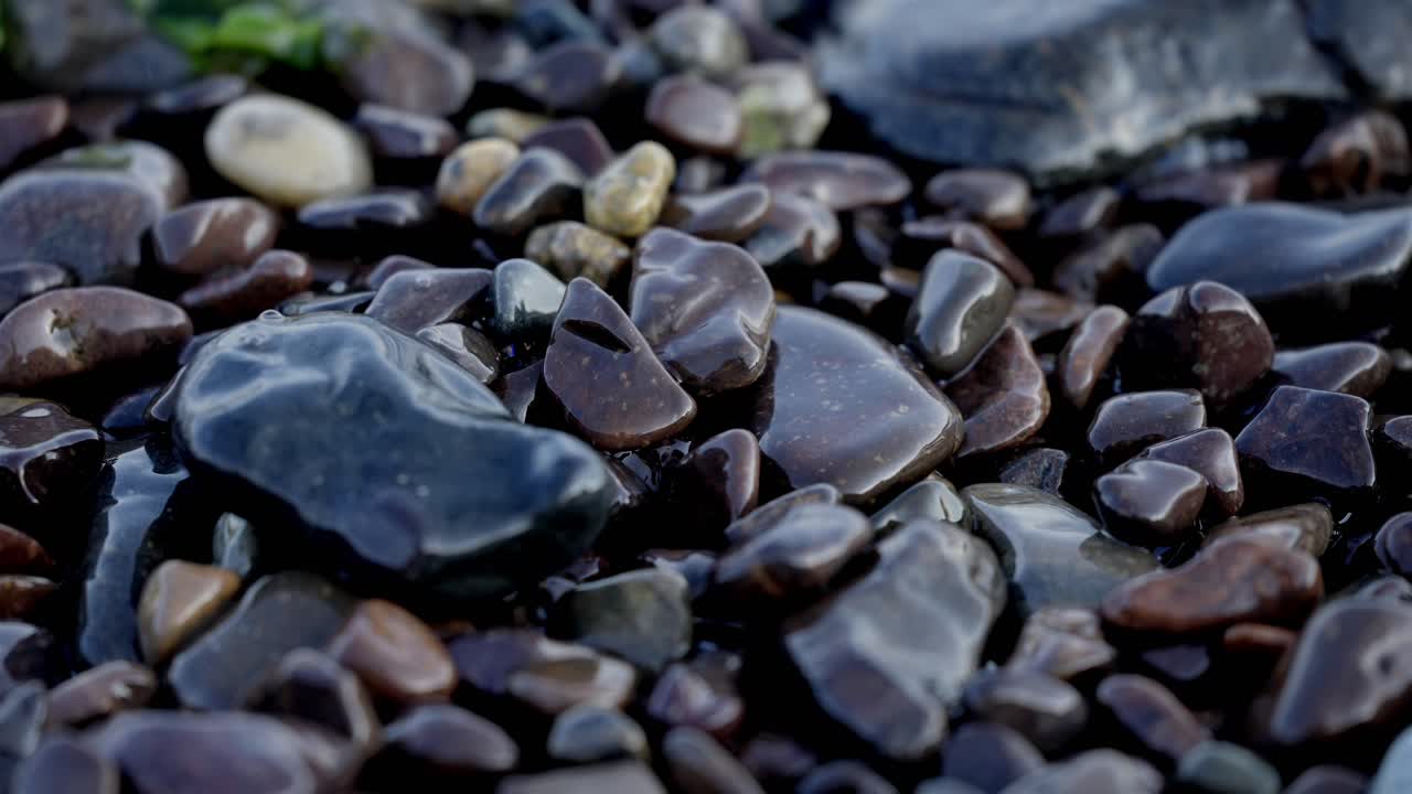 Nature background, a macro shot of clear water over shiny pebbles