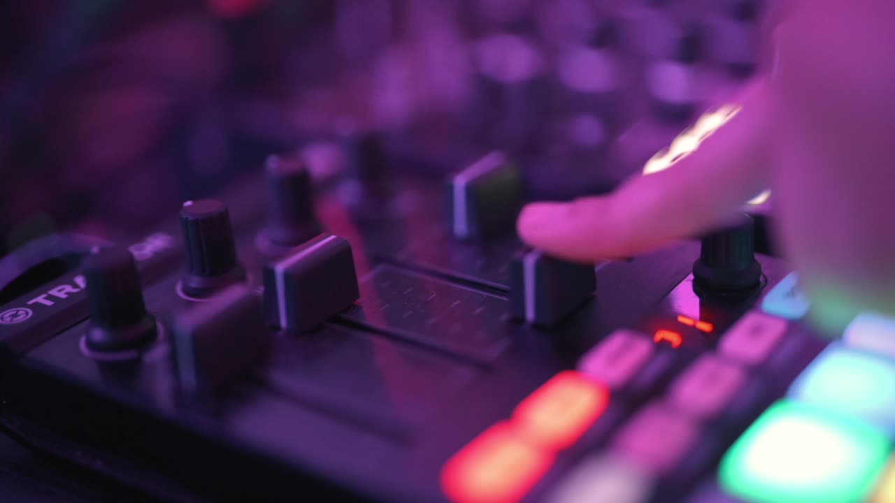 Makro nærbillede detalje af DJ-hånd, der justerer volumenfader på professionel mixerpult i mørk klub