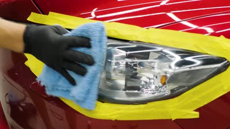 headlight polishing, processing of car lights. a car service worker polishes the headlight of a passenger car. professional polishing.