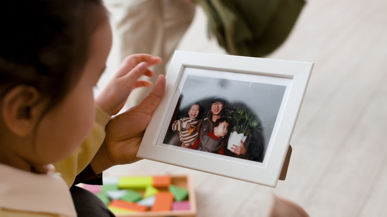 Child Cleaning a Family Photo Frame