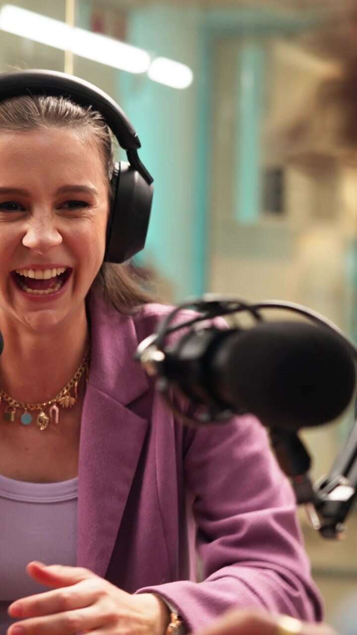 Giovane donna che ride durante la registrazione di un podcast in studio