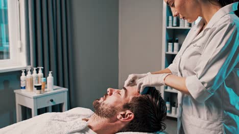 man receiving facial treatment at a spa