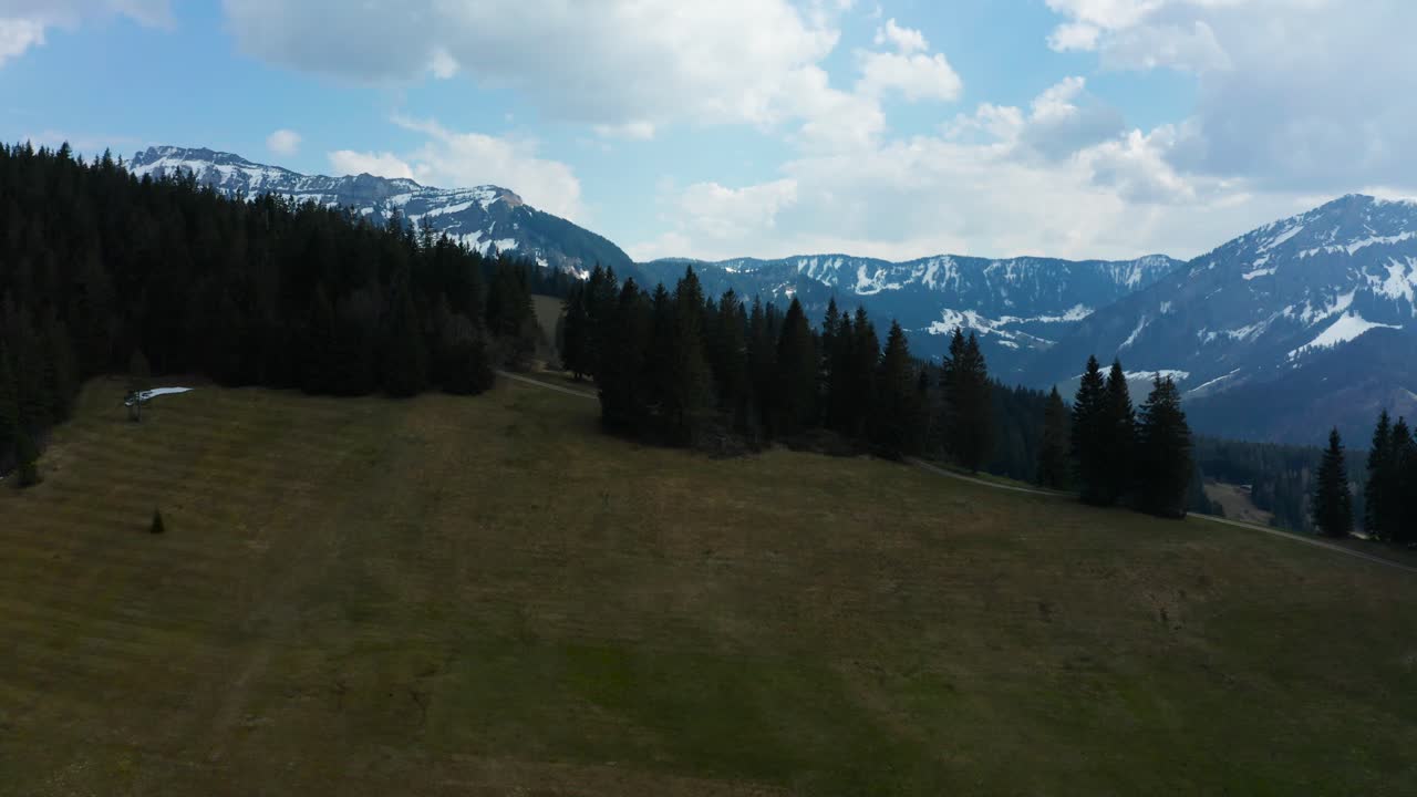 vista aérea suave del paisaje montañoso en entlebuch, suiza, tiempo de primavera con pinos y montañas nevadas nubladas