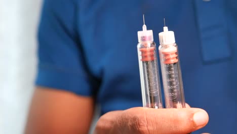 person holding two syringes