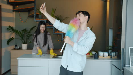 couple cleaning the kitchen with fun