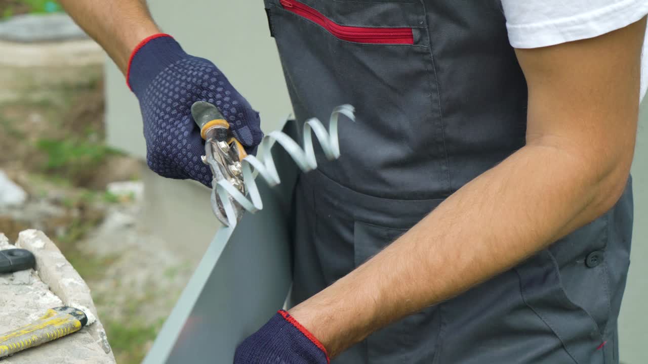 Worker hands in protective gloves preparing PVC window sill cutting metal with scissors closeup