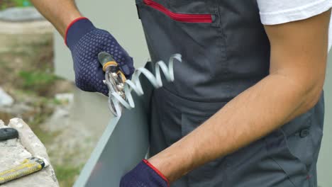 worker hands in protective gloves preparing pvc window sill cutting metal with scissors closeup