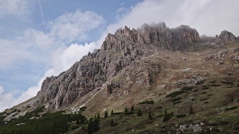 clouds move over jagged dolomite mountain peak in scenic sky view low angle