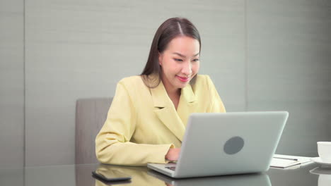 An-attractive-young-woman-in-business-attire-works-diligently-on-her-laptop